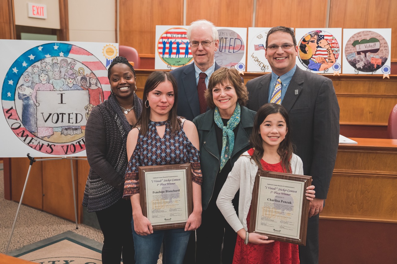 1st place contest winners Penelope Blanchard (left) and Charlisa Penzak (right) with members of the Board's Women's Suffrage Committee, which include (left to right) Angela Powell, Tom Kuhn, Marcia Gershenson and Dave Woodward.